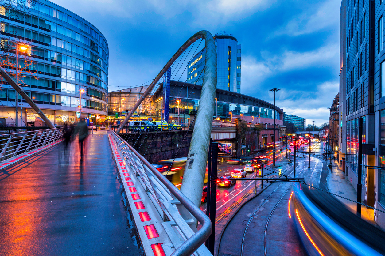 A long exposure of Manchester Piccadilly showing silhouettes of people moving and strikes of lights from the trams passing.